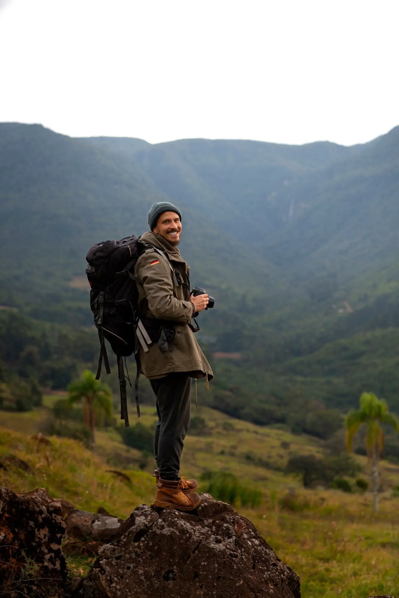 Ganzkörperaufnahme eines abenteuerlustigen Mannes beim Biwakieren.