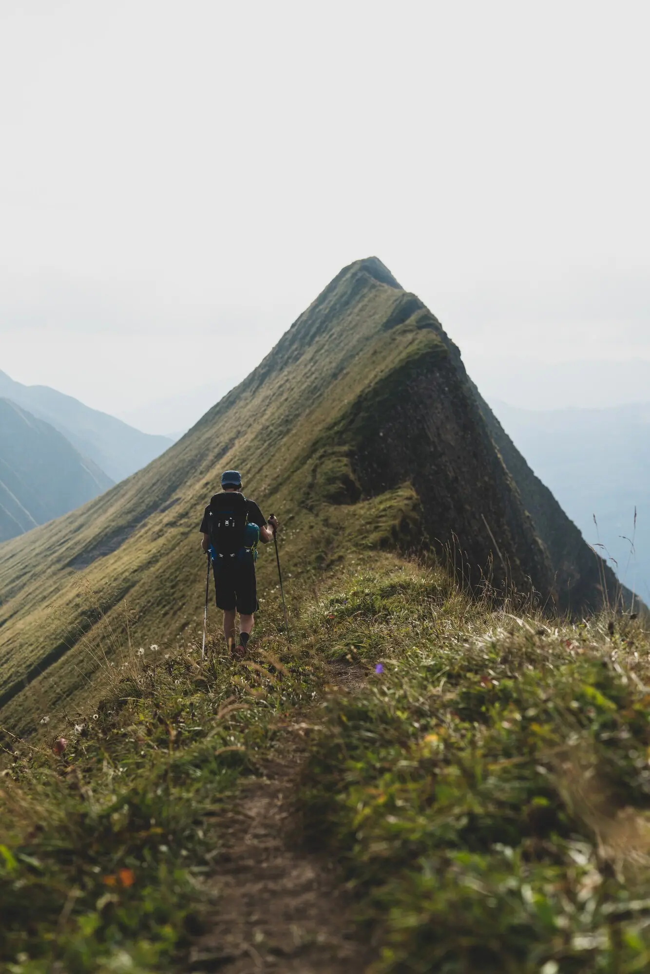 Hochformataufnahme eines Wanderers auf dem Hardergrat-Trail in den Schweizer Alpen